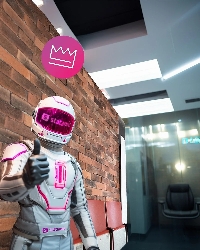 Figur mit Statamic-Helm zeigt den Daumen hoch in einem Büro mit Backsteinwand
