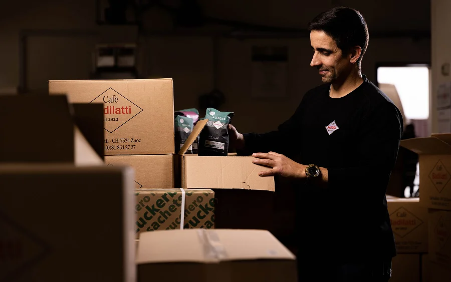 Verpacken im Lager: Kaffeepackungen werden in einen Badilatti-Karton gelegt