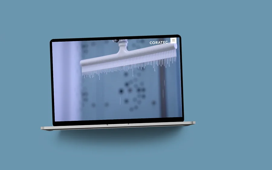 Die Coratec-Website im MacBook auf blaugrauer Fläche: Startseite mit einer Sandwichplatte im Tauchbad
