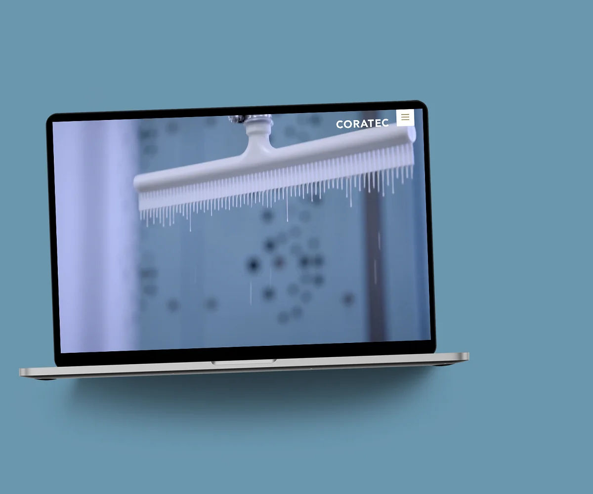 Die Coratec-Website im MacBook auf blaugrauer Fläche: Startseite mit einer Sandwichplatte im Tauchbad