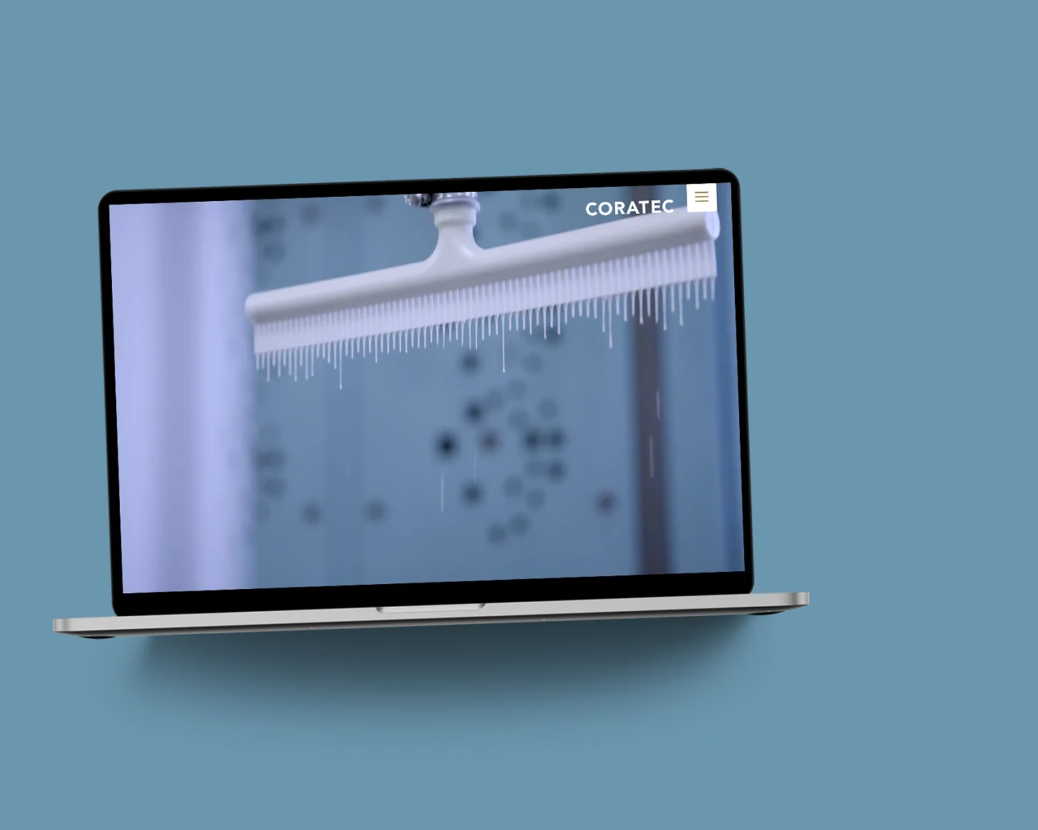 Die Coratec-Website im MacBook auf blaugrauer Fläche: Startseite mit einer Sandwichplatte im Tauchbad