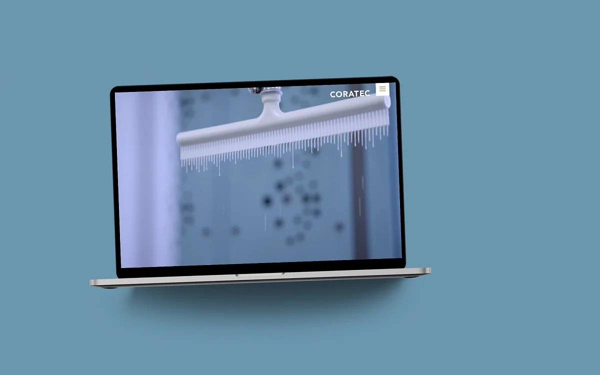 Die Coratec-Website im MacBook auf blaugrauer Fläche: Startseite mit einer Sandwichplatte im Tauchbad