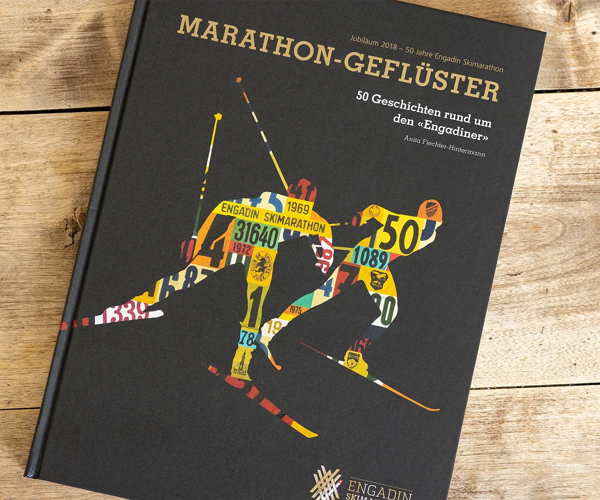 Das Jubiläumsbuch «Marathon-Geflüster» liegt geschlossen auf Holz, unten das ESM-Signet in Gold
