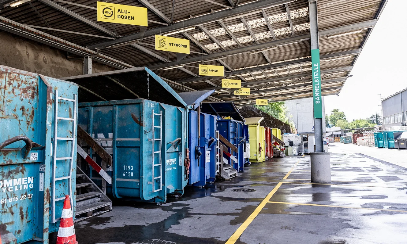 Überdachte Sammelstelle mit Containern, darüber die Hängeschilder Alu-Dosen, Styropor, Papier und Karton