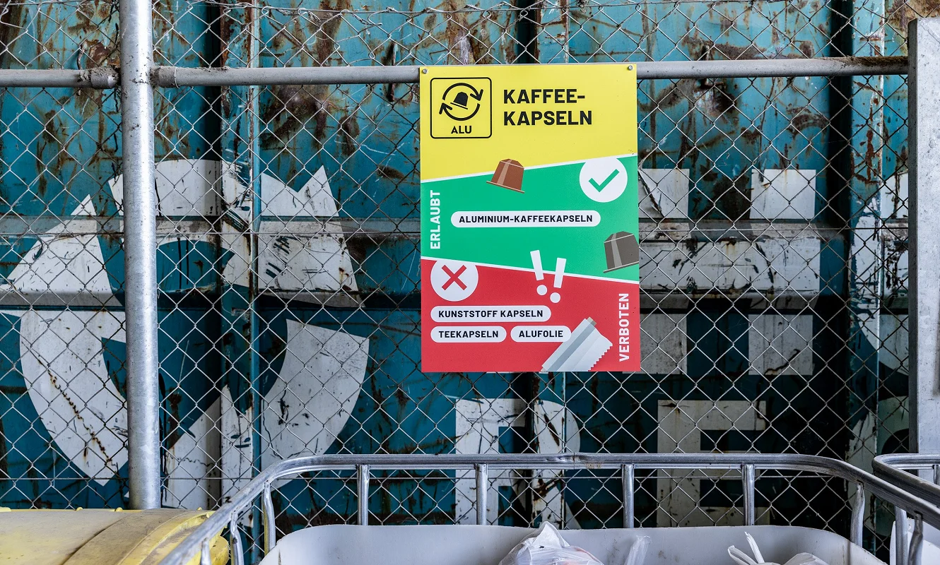 Tafel «Kaffeekapseln» am Gitterzaun mit Erlaubt- und Verboten-Liste