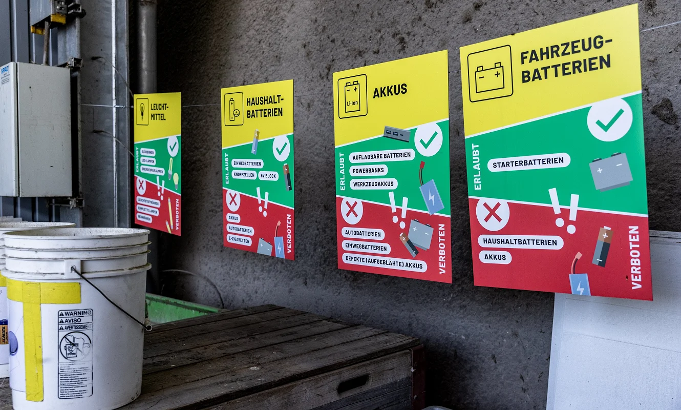 Vier Tafeln nebeneinander an der Wand: Leuchtmittel, Haushaltbatterien, Akkus und Fahrzeugbatterien