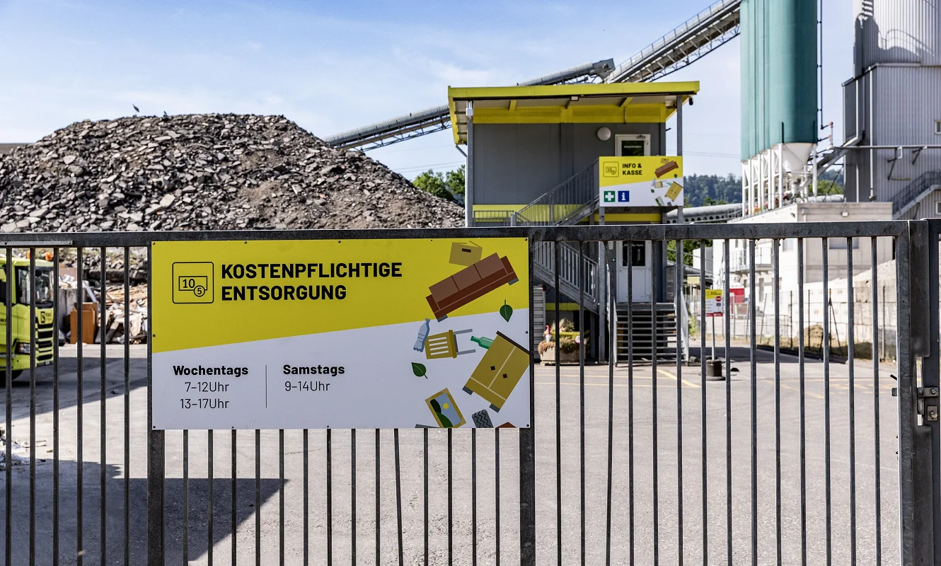 Tafel «Kostenpflichtige Entsorgung» mit Öffnungszeiten am Eingangstor des Areals