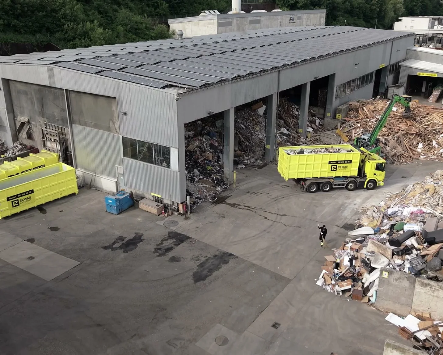 Standbild aus dem Headerfilm: Luftaufnahme des Areals mit Lastwagen und Mulden vor der Sortierhalle