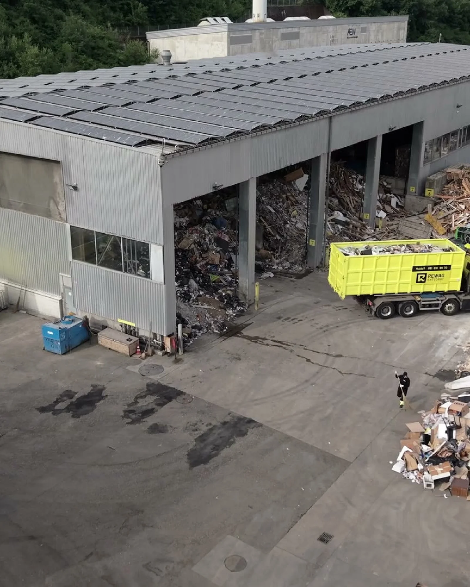 Standbild aus dem Headerfilm: Luftaufnahme des Areals mit Lastwagen und Mulden vor der Sortierhalle