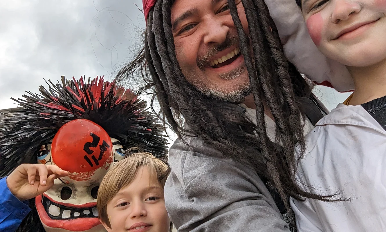 Patrick an der Fasnacht mit zwei Kindern, links eine Waggis-Maske