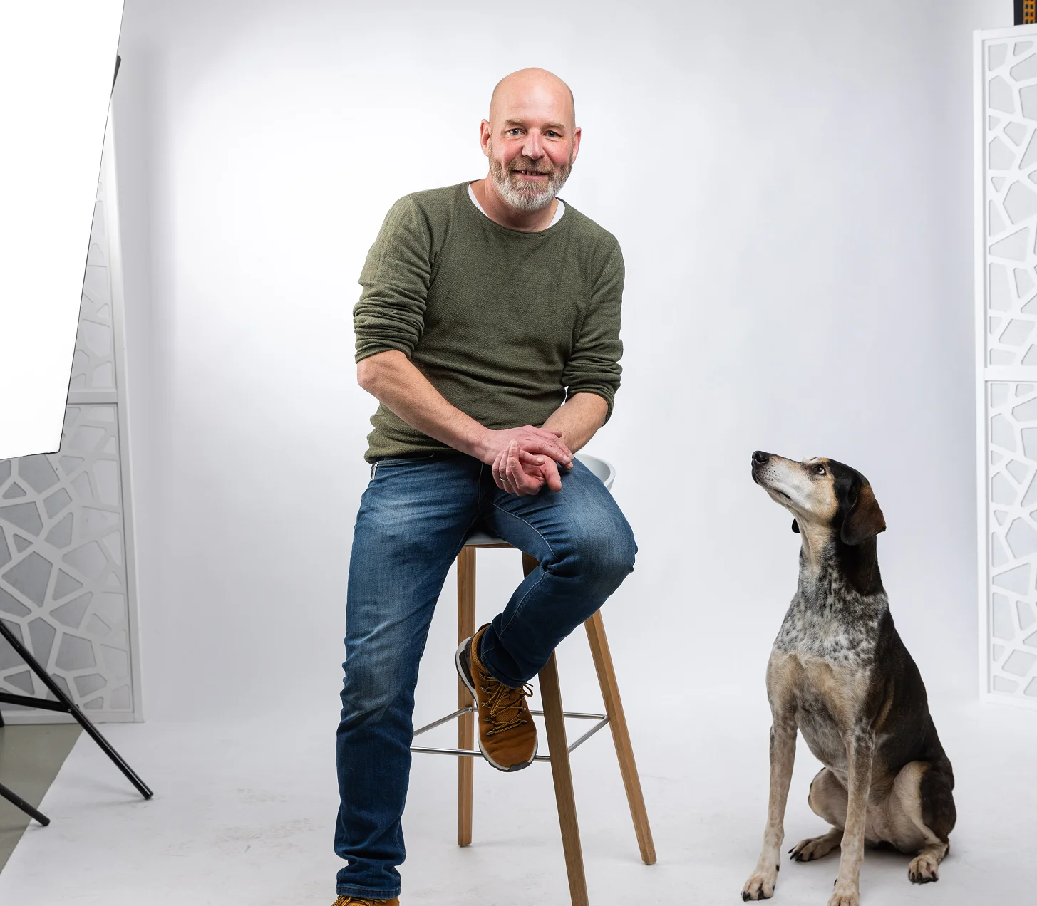 Roger auf dem Hocker im Fotostudio, daneben Inge zwischen den Studioleuchten